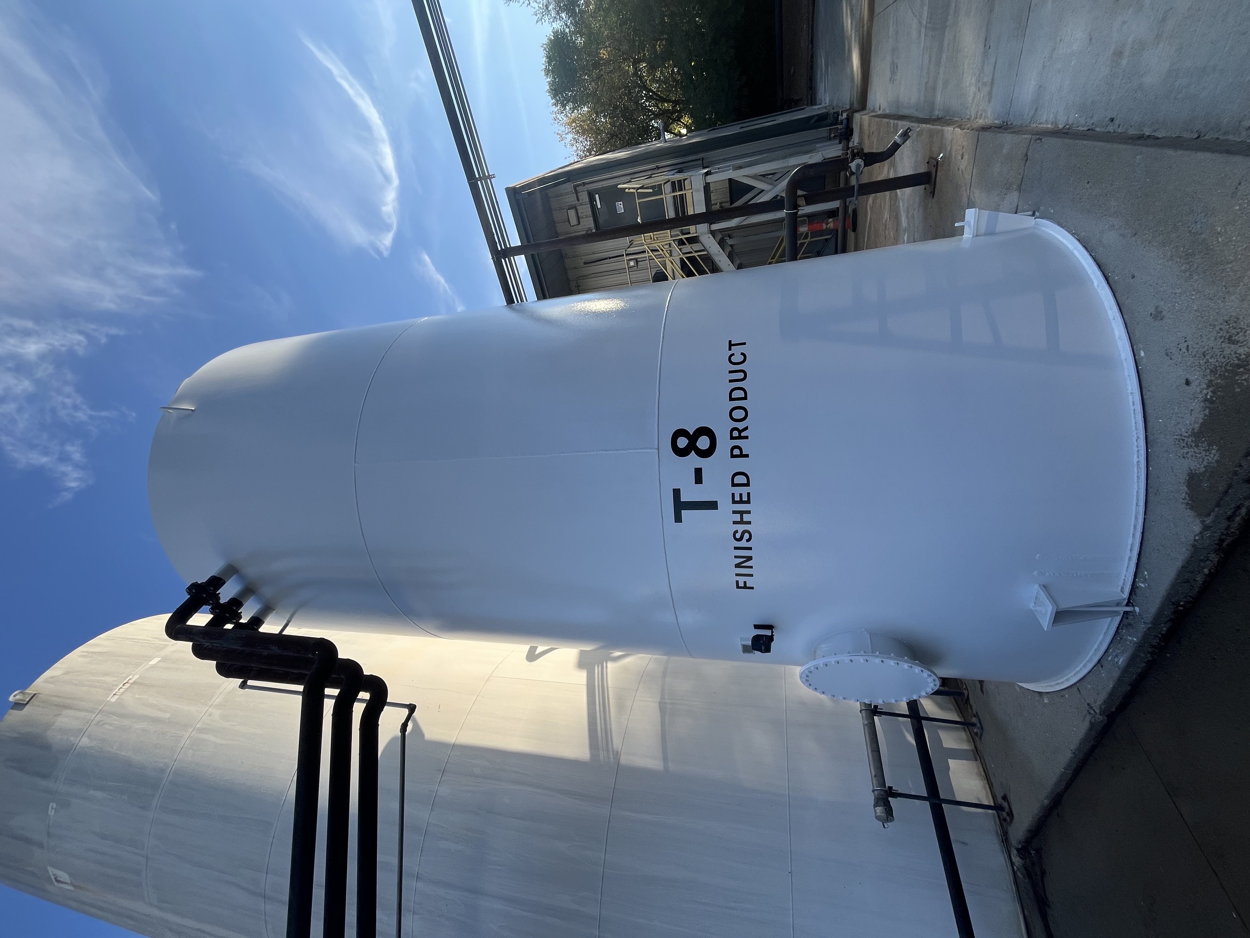 Recoated finished-product storage tank labeled T-8 at an industrial facility